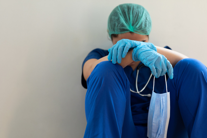 What Healthcare Travelers Should Do in an Emergency Situation Stressed tired healthcare worker sitting on floor