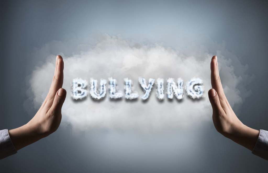 Nurses and Bullying: How to Handle It Women showing stop sign with text "BULLYING" (Click for more)