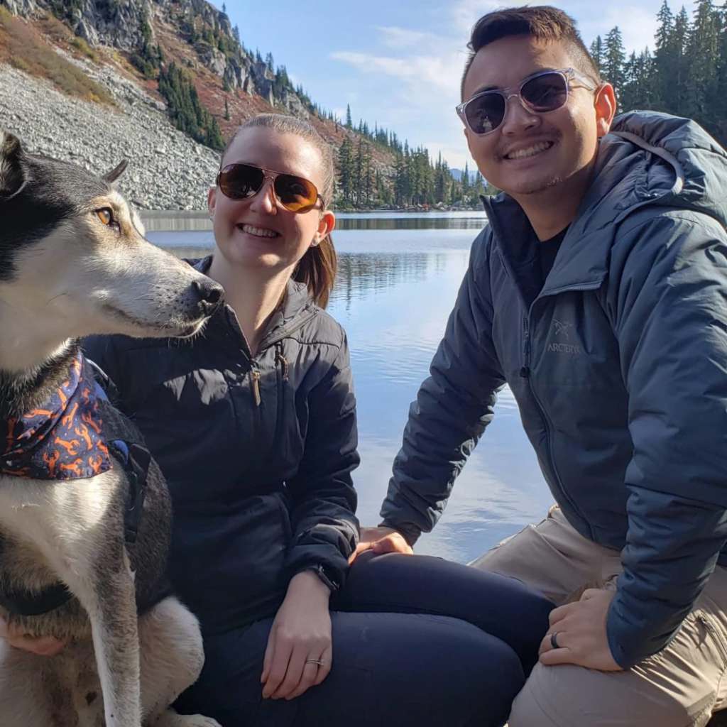 TotalMed Travel Nurse Is Bright Spot in Patient’s Hospitalization couple poses with their dog in front of lake and mountain landscape